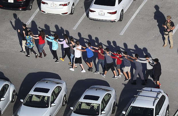 Students form a chain as they are brought out of the school. Joe Raedle/Getty Images