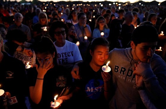 People attend a candlelight vigil for victims of the shooting at nearby Marjory Stoneman Douglas High School, in Parkland, Florida, February 15, 2018. REUTERS/Carlos Garcia Rawlins