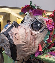 A giant papier-mâché dog’s head sits on a workbench, a symbol of the year that is to usher in a time of fairness and equality.