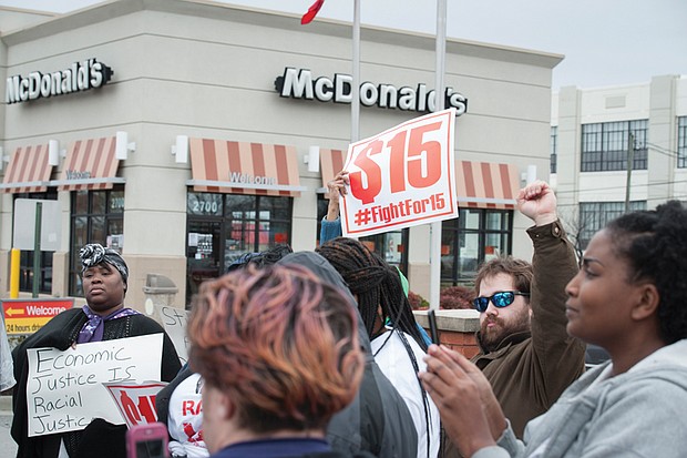 On Monday, protests were held across the nation marking the anniversary of the Memphis strike and calling for higher wages for workers. Bernadette Brown, left, holds a sign outside a Richmond fast food restaurant, while Daniel Henegar, right, and others show their support. The protests were organized by Fight for $15 and the New Poor People’s Campaign, which is led by the Rev. William J. Barber II of North Carolina.