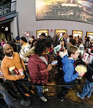 Crowds wait for the theater to open Saturday at the Bow Tie Movieland for the superhero film. 