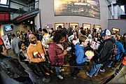 Crowds wait for the theater to open Saturday at the Bow Tie Movieland for the superhero film. 