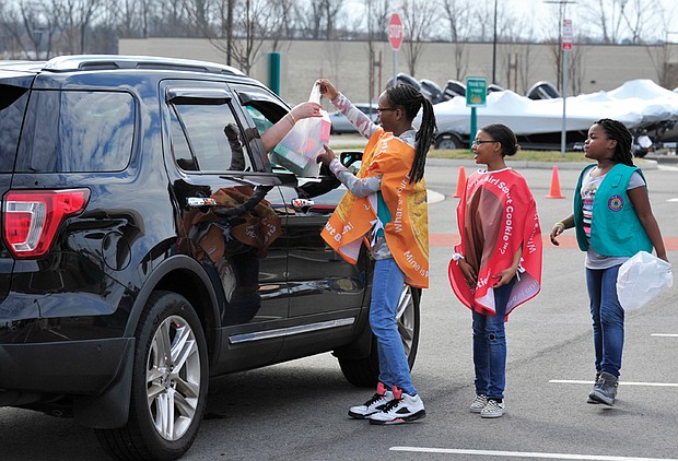 Going all out for Girl Scout cookies //  If there’s any question about the power of Girl Scout cookies, look no further. Car loads of customers head through a Girl Scout cookie drive-thru Saturday in the parking lot of Cabela’s sporting goods store in Short Pump, where scouts from area troops assisted them with purchases of  their favorite cookie varieties as part of National Girl Scout Cookie Weekend. Above, scouts Dionne Washington, Tyshaunda Jennings and DeRanae Jones of Troop #007 fill a motorist’s cookie order
