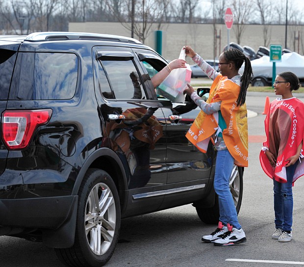 Going all out for Girl Scout cookies //  If there’s any question about the power of Girl Scout cookies, look no further. Car loads of customers head through a Girl Scout cookie drive-thru Saturday in the parking lot of Cabela’s sporting goods store in Short Pump, where scouts from area troops assisted them with purchases of  their favorite cookie varieties as part of National Girl Scout Cookie Weekend. Above, scouts Dionne Washington, Tyshaunda Jennings and DeRanae Jones of Troop #007 fill a motorist’s cookie order
