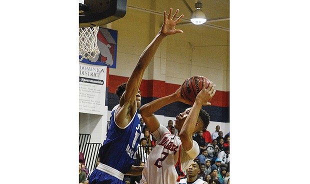 John Marshall High School’s Isaiah Todd, left, stretches to block a shot by George Wythe High’s Darrell Purdie during last Friday’s regional final. While John Marshall won the game 83-64, both teams will play in the state quarterfinals this weekend.