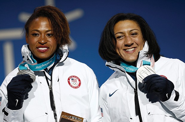 Lauren Gibbs, left, and Elena Meyers Taylor show off their silver medals won in the two-woman bobsled competition Feb. 22 as they stand for the medals ceremony at the Winter Olympics in Pyeongchang, South Korea.