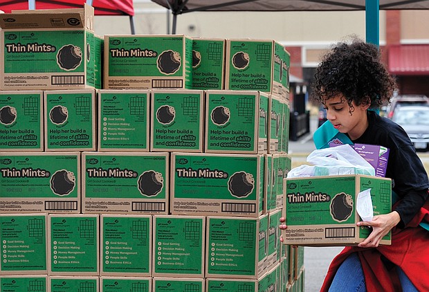 Scout Sahmeah Jamison, right, carefully balances a box to complete another order. Cookie sales will continue around the Richmond area through   late March.
