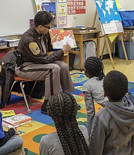 The joy of reading // Adults are spreading the joy of reading to area children. Left, Richmond Sheriff Antionette V. Irving reads to students at Overby-Sheppard Elementary School in North Side on Tuesday

