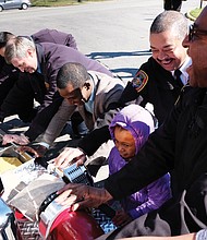 All hands on deck // 
Richmond Fire Chief Melvin Carter, right, leads the charge to push a new fire truck into its new berth at Station 14 at 2932 Hawthorne Ave. in North Side. Among those helping during the traditional housing ceremony Saturday were Mayor Levar M. Stoney and 6-year-old Noah Ashe, whose family lives in a home just doors away from the station. Noah attended the ceremony with her dad, Jonathan Ashe, and year-old brother, David.