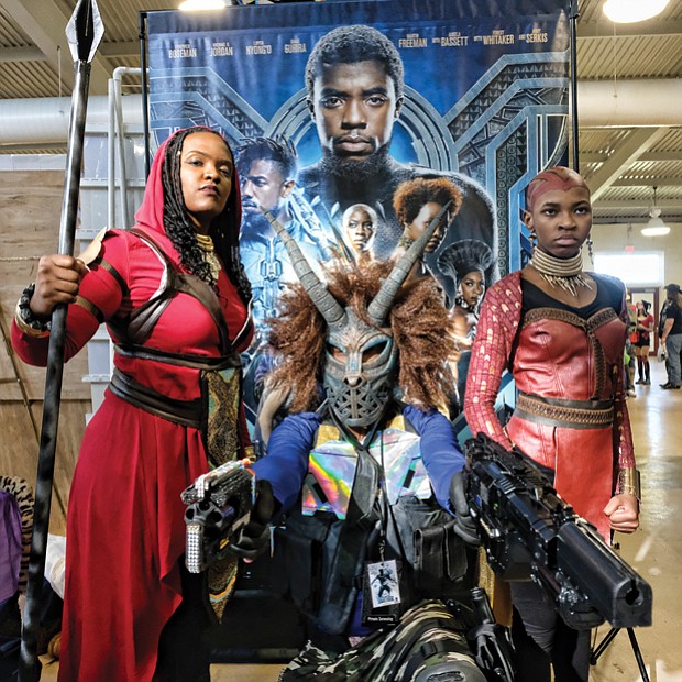 ‘Black Panther’ flair // This trio appears to be straight out of the film “Black Panther” as they take part in VA Comicon last Saturday at the Old Dominion Building at Richmond Raceway. Frank Lester, center, is outfitted as the movie’s super villain Erik Killmonger. Mia Jones, left, and 12-year-old Cameron Hilliard are dressed as Wakanda warriors, also known as Dora Milaje, the team of female special forces protecting the film’s fictional African nation of Wakanda. VA Comicon, where comic books and toys take center stage, was filled with participants who dressed as popular characters. 

