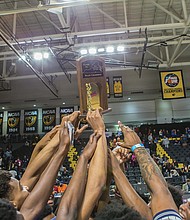 Jubilant John Marshall players show off their 3A state championship trophy after their big victory last Friday at Virginia Commonwealth University’s Siegel Center. This was the Justices first visit to the winner’s circle at the state level since 2014.   