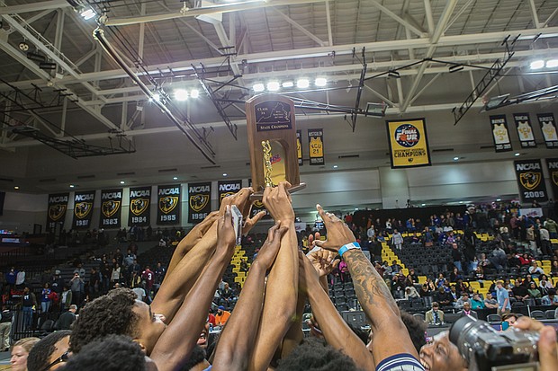 Jubilant John Marshall players show off their 3A state championship trophy after their big victory last Friday at Virginia Commonwealth University’s Siegel Center. This was the Justices first visit to the winner’s circle at the state level since 2014.   