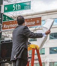 In his honor // Raymond H. Boone Jr. unveils the honorary street sign that pays tribute to his father, the late founder, publisher and editor of the Richmond Free Press. Location: 5th and Franklin streets in front of the Free Press building.