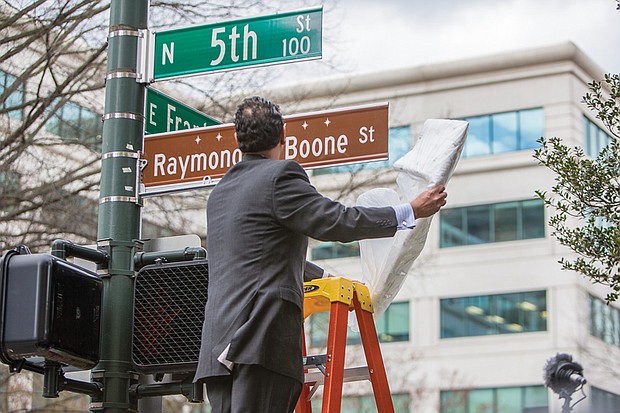 In his honor // Raymond H. Boone Jr. unveils the honorary street sign that pays tribute to his father, the late founder, publisher and editor of the Richmond Free Press. Location: 5th and Franklin streets in front of the Free Press building.