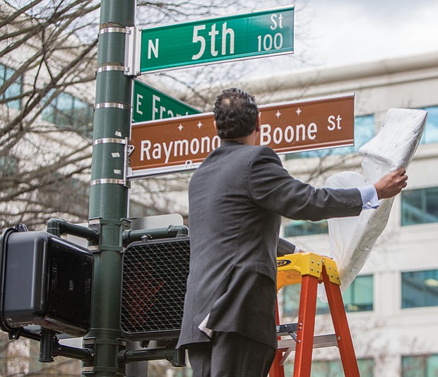 In his honor // Raymond H. Boone Jr. unveils the honorary street sign that pays tribute to his father, the late founder, publisher and editor of the Richmond Free Press. Location: 5th and Franklin streets in front of the Free Press building.