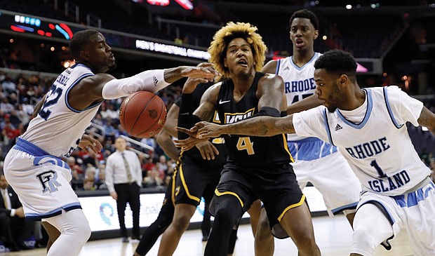 Virginia Commonwealth University forward Justin Tillman loses the ball in a squeeze by University of Rhode Island players during the Atlantic 10 Conference Tournament. Rhode Island defeated the Rams 76-67.