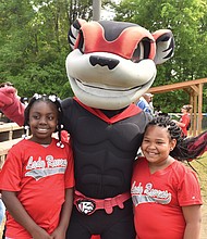 Nutzy, the mascot of the Richmond Flying Squirrels, takes a photo with members of the G.H. Reid Lady Ravens squad during the June 2017 opening day at Blackwell Community Center, where the Flying Squirrels Charities has provided a facelift to the South Side field, pitching mound and dugouts during the past two years.