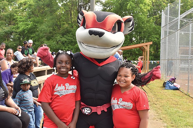 Nutzy, the mascot of the Richmond Flying Squirrels, takes a photo with members of the G.H. Reid Lady Ravens squad during the June 2017 opening day at Blackwell Community Center, where the Flying Squirrels Charities has provided a facelift to the South Side field, pitching mound and dugouts during the past two years.