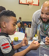 Better health //
Elijah Kersey, 5, squeezes a pliable figure of a sumo wrestler as he visits with Jaquelle Scott at the Second Chances Comprehensive Services booth last Saturday at the annual Virginia Commonwealth University Wellness Block Party. The event, held at Martin Luther King Jr. Middle School in the East End, offered health screenings, information and consultations with health professionals. It was the 11th year for the community event put on by VCU students with the assistance of physicians and community organizations. Second Chances provides mental health counseling for youths and adults, case management and links to other community resources.