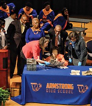 Former schools Superintendent Lucille M. Brown, seated center, an Armstrong High School alumna, describes for the audience the contents of the 1952 time capsule found during demolition of the former Armstrong building on 31st Street. Dr. Brown is flanked by Meg Hughes, left, of The Valentine museum and architectural historian Kimberly Chen who were handling the fragile items. Looking on are, from left, Armstrong Principal Willie Bell, School Board member Cheryl L. Burke and Dennis H. Harvey, chair of the Armstrong High School Alumni Coalition.