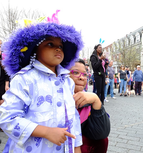 Audrey Ross, 4, pauses with her mother, Tarah Westont, to watch one of the performances at Easter on Parade.
