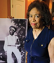 Josephine Bolling McCall stands with a photo of her father, Elmore Bolling, a successful businessman who was lynched in 1947 when Mrs. McCall was only 5.