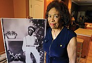 Josephine Bolling McCall stands with a photo of her father, Elmore Bolling, a successful businessman who was lynched in 1947 when Mrs. McCall was only 5.