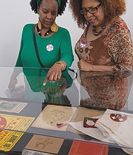  Sonja Holt, left, and Dawn Howard peruse a display in the exhibition “Storm in the Time of Shelter” by artist Paul 