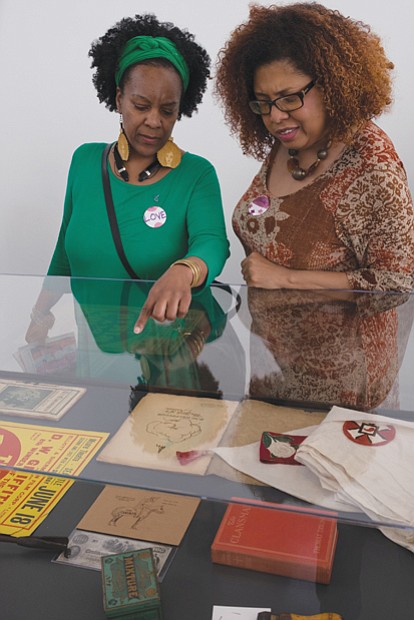  Sonja Holt, left, and Dawn Howard peruse a display in the exhibition “Storm in the Time of Shelter” by artist Paul 