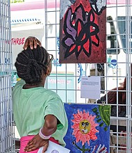 Into the art //
Samaya Waldo, 10, contemplates the work of Kareen Jones, a Fairfield Middle School student, during ART 180’s “The Really Big Show.” The festivities drew hundreds of art lovers last Saturday to the grounds of the Science Museum of Virginia. Please see more photos, Page B2. 
