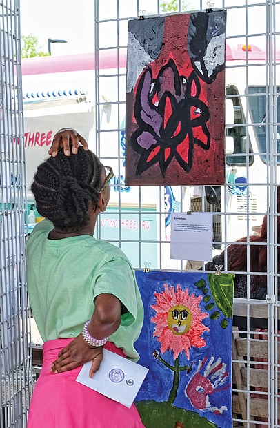 Into the art //
Samaya Waldo, 10, contemplates the work of Kareen Jones, a Fairfield Middle School student, during ART 180’s “The Really Big Show.” The festivities drew hundreds of art lovers last Saturday to the grounds of the Science Museum of Virginia. Please see more photos, Page B2.