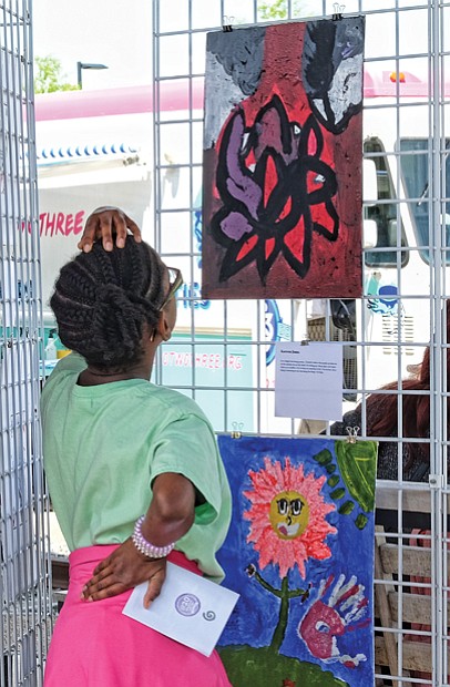 Into the art //
Samaya Waldo, 10, contemplates the work of Kareen Jones, a Fairfield Middle School student, during ART 180’s “The Really Big Show.” The festivities drew hundreds of art lovers last Saturday to the grounds of the Science Museum of Virginia. Please see more photos, Page B2. 