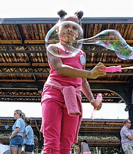 Jo-lynn Carter creates big bubbles, below, in the kids’ activity zone // 