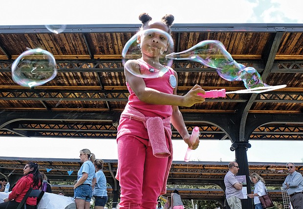 Jo-lynn Carter creates big bubbles, below, in the kids’ activity zone //