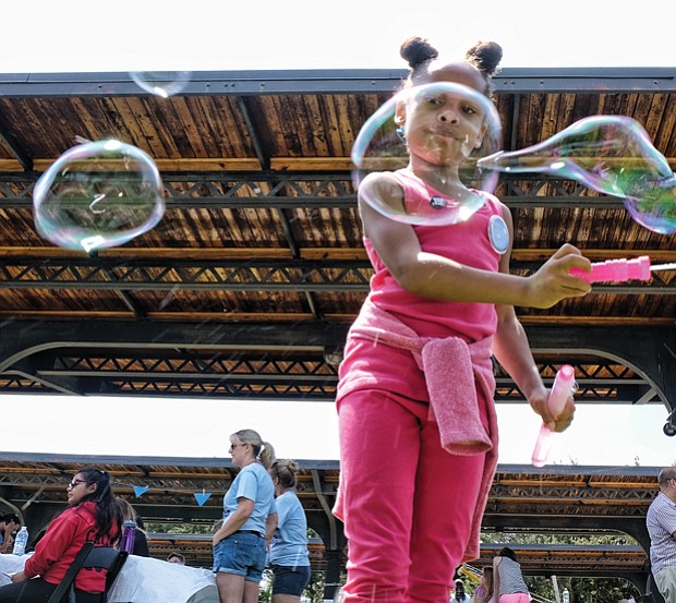 Jo-lynn Carter creates big bubbles, below, in the kids’ activity zone // 