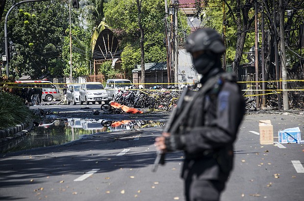 An Indonesian anti-terror policeman stands guard at the site of one of the bombings Sunday.