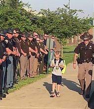 When Dakota Pitt's, 5, returned to school at Sullivan Elemntary School in western Indiana, for the first time after his police officer dad's death, 70 cops stood beside him  Credit: Samantha Phegley/Sulivan Elementary School