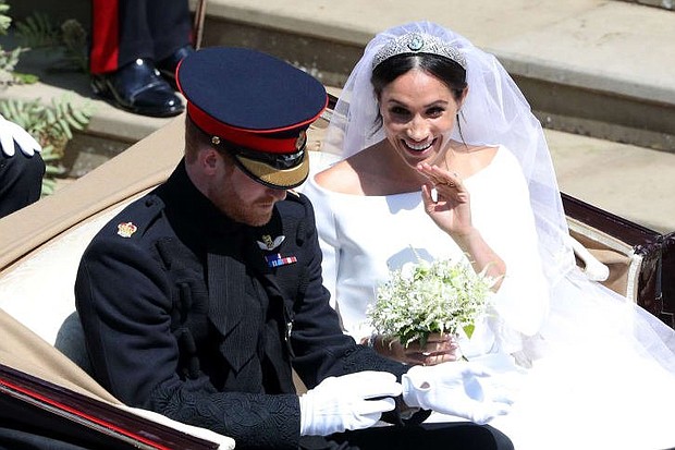 	The Duke and Duchess of Sussex wave to the waiting crowds as they depart Windsor Castle.
