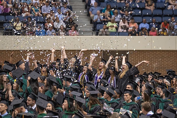 Nursing school graduates throw handfuls of confetti and glitter in celebration after Virginia Commonwealth University announces their degrees are conferred during Saturday’s ceremony at the Richmond Coliseum.