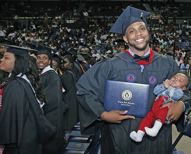Shaquille Robinson, right, shows off his new bachelor’s degree and his young son, Shaquille Jr., during the afternoon commencement on Mother’s Day.