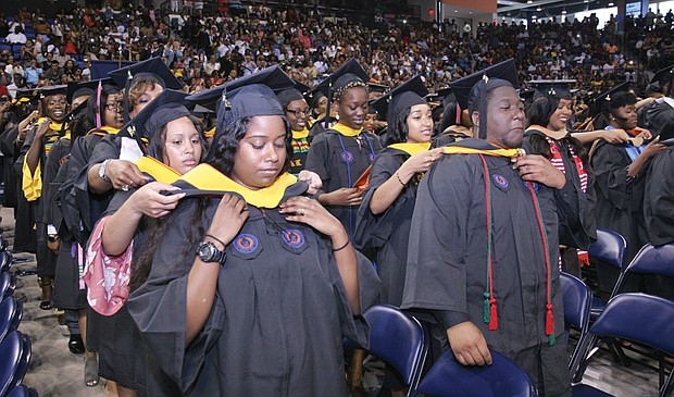 New graduates of Virginia State University help place each others’ hoods signifying their new degrees during commencement ceremonies Sunday at the VSU Multi-Purpose Center. Shaquille Robinson