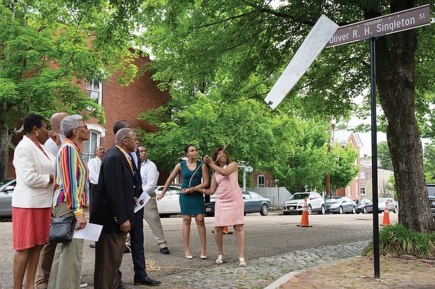 Singleton honored // Christopher Smith

Rose Singleton, right, unveils the honorary street sign renaming the 2700 block of East Grace Street after her late husband, Oliver R.H. Singleton, president and chief executive officer of the Metropolitan Business League. Richmond City Council voted in February to authorize the sign to honor Mr. Singleton’s role as an advocate for minority-owned and small business development. Dozens of family members and friends were on hand for the ceremony Tuesday. Helping to remove the sign are the Singletons’ daughter, Christine, and son, Oliver. 
