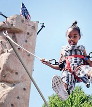 Fun for a cause // Ava Miller flies high on a bungee bouncer at last Saturday’s Strawberry Street Festival in The Fan. It was the 39th year for the event sponsored by the William H. Fox Elementary School PTA to benefit the public school in Richmond. 
