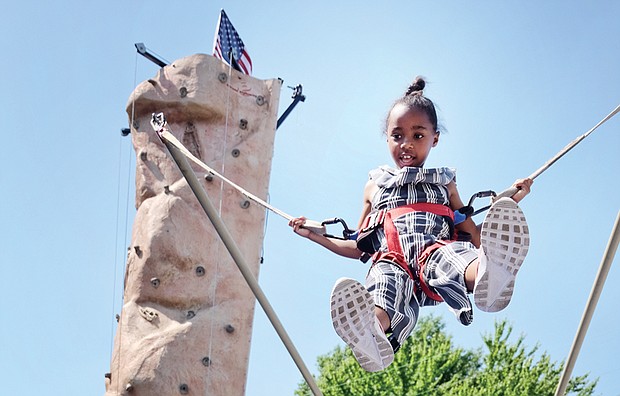 Fun for a cause // Ava Miller flies high on a bungee bouncer at last Saturday’s Strawberry Street Festival in The Fan. It was the 39th year for the event sponsored by the William H. Fox Elementary School PTA to benefit the public school in Richmond. 
