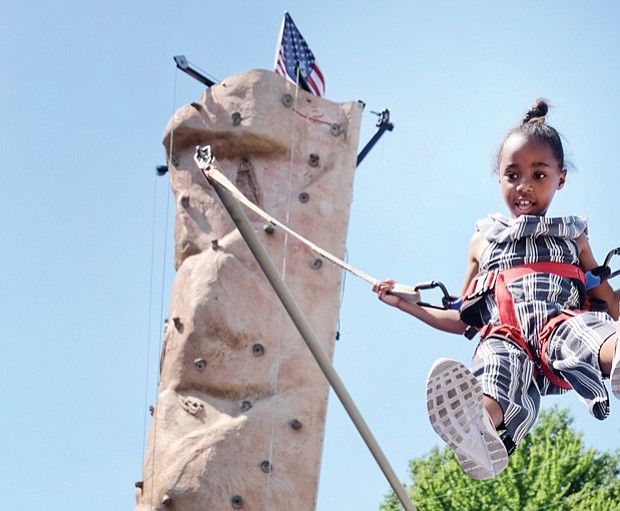 Fun for a cause // Ava Miller flies high on a bungee bouncer at last Saturday’s Strawberry Street Festival in The Fan. It was the 39th year for the event sponsored by the William H. Fox Elementary School PTA to benefit the public school in Richmond. 
