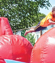 Fun for a cause //
The festival features games, rides, strawberries and other foods, crafts and a book sale. Below, Bray Sumler, 8, takes a dive onto the leaps and bounds apparatus at the festival.