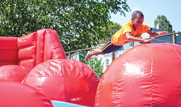 Fun for a cause //
The festival features games, rides, strawberries and other foods, crafts and a book sale. Below, Bray Sumler, 8, takes a dive onto the leaps and bounds apparatus at the festival.