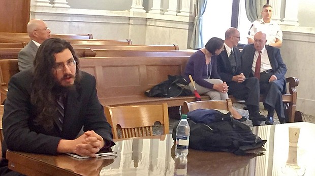 Michael Rotondo (left) at his eviction proceeding in Syracuse, New York. His parents, Mark and Christina, confer with their lawyer in the court gallery behind.  CREDIT: Douglas Dowty/The Syracuse Newspapers via AP