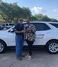 Ray Aguilar, Community Relations Director at Classic Chevrolet of Sugar Land, presents 2017-18 Stafford MSD District Teacher of the Year Ashley Bratcher with a free lease on a 2018 Chevrolet Equinox for the month of June. Aguilar invited Bratcher to return to the Classic dealership in July and August, respectively, to select another free lease for those months