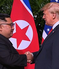 Donald Trump and Kim Jong Un shake hands